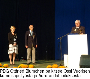 PDG Ottfried Blumchen palkitsee Ossi Vuorisen kummilapsityst ja Auroran lahjoituksesta