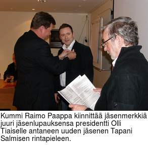 Kummi Raimo Paappa kiinnitt jsenmerkki juuri jsenlupauksensa presidentti Olli Tiaiselle antaneen uuden jsenen Tapani Salmisen rintapieleen.