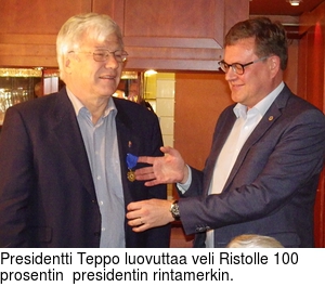 Presidentti Teppo luovuttaa veli Ristolle 100 prosentin  presidentin rintamerkin.