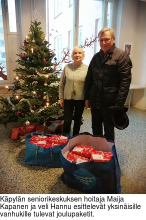 Kpyln seniorikeskuksen hoitaja Maija Kapanen ja veli Hannu esittelevt yksinisille vanhukille tulevat joulupaketit.