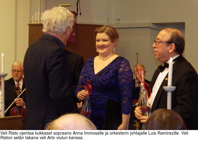 Veli Risto ojentaa kukkaset sopraano Anna Immoselle ja orkesterin johtajalle Luis Ramirezille. Veli Riston seln takana veli Arto viulun kanssa.