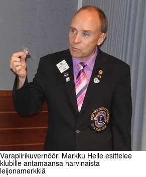 Varapiirikuvernri Markku Helle esittelee klubille antamaansa harvinaista leijonamerkki