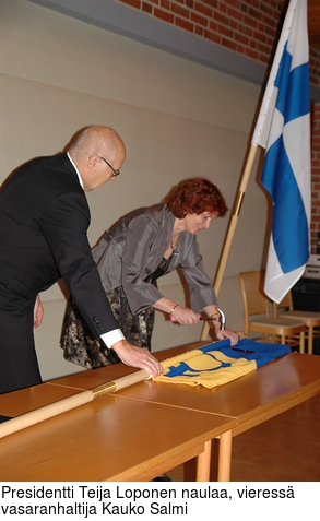 Presidentti Teija Loponen naulaa, vieress vasaranhaltija Kauko Salmi
