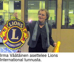 Irma Vtinen asettelee Lions International tunnusta.