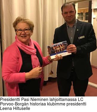 Presidentti Pasi Nieminen lahjoittamassa LC Porvoo-Borgn historiaa klubimme presidentti Leena Hiltuselle