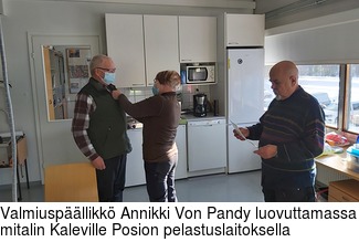 Valmiuspllikk Annikki Von Pandy luovuttamassa mitalin Kaleville Posion pelastuslaitoksella