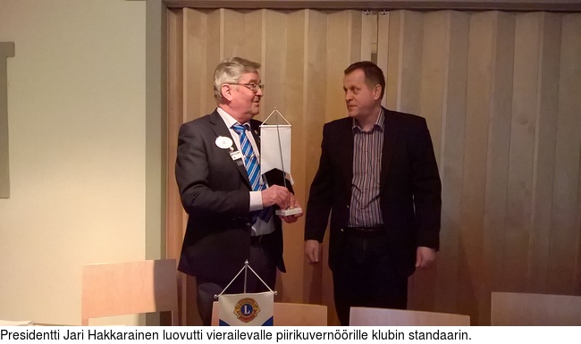 Presidentti Jari Hakkarainen luovutti vierailevalle piirikuvernrille klubin standaarin.