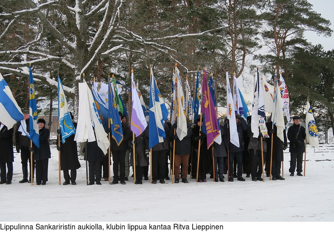 Lippulinna Sankariristin aukiolla, klubin lippua kantaa Ritva Lieppinen