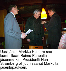 Uusi jsen Markku Heinaro saa kummiltaan Raimo Paapalta jsenmerkin. Presidentti Harri Strmberg oli juuri saanut Markulta jsenlupauksen.