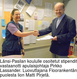 Lnsi-Pasilan koululle osoitetut stipendit vastaanotti apulaisjohtaja Pirkko Lassander. Luovuttajana Floorankentn puolesta lion Matti Pirjet.
