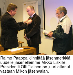Raimo Paappa kiinnitt jsenmerkki uudelle jsenellemme Mikko Liskille.  Presidentti Olli Tiainen on juuri ottanut vastaan Mikon jsenvalan.