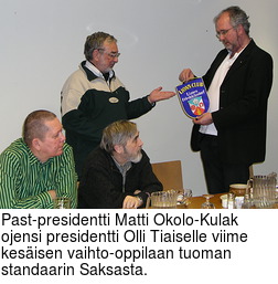 Past-presidentti Matti Okolo-Kulak ojensi presidentti Olli Tiaiselle viime kesisen vaihto-oppilaan tuoman standaarin Saksasta.