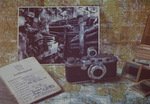 Sota-alueen kartan pll Aukusti Tuhkan sotilaspassi ja Leica-kamera sek kuva juoksuhaudasta.
