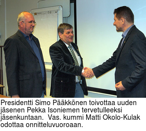 Presidentti Simo Pkknen toivottaa uuden jsenen Pekka Isoniemen tervetulleeksi jsenkuntaan.  Vas. kummi Matti Okolo-Kulak odottaa onnitteluvuoroaan.