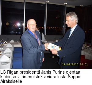 LC Rigan presidentti Janis Purins ojentaa klubinsa viirin muistoksi vierailusta Seppo Airaksiselle