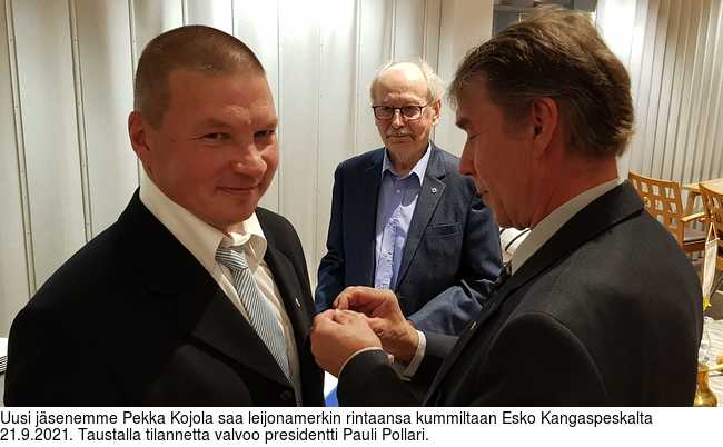 Uusi jsenemme Pekka Kojola saa leijonamerkin rintaansa kummiltaan Esko Kangaspeskalta 21.9.2021. Taustalla tilannetta valvoo presidentti Pauli Pollari.