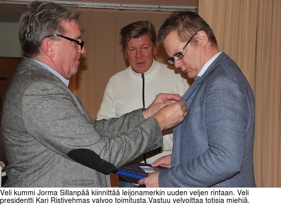Veli kummi Jorma Sillanp kiinnitt leijonamerkin uuden veljen rintaan. Veli presidentti Kari Ristivehmas valvoo toimitusta.Vastuu velvoittaa totisia miehi.