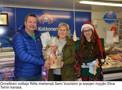 Onnellinen voittaja Riitta miehens Sami Vuoriston ja arpojen myyjn Elina Teinin kanssa.