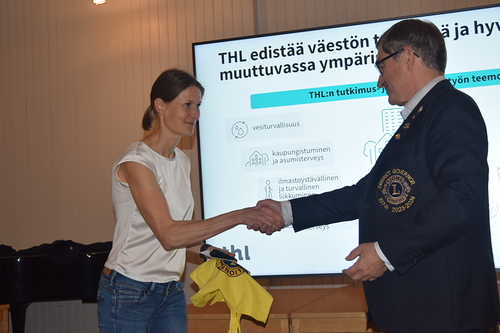 Piirikuvernri Pekka Taskinen antoi piirin ekologisen kassin kiitokseksi Jaana Haloselle.
