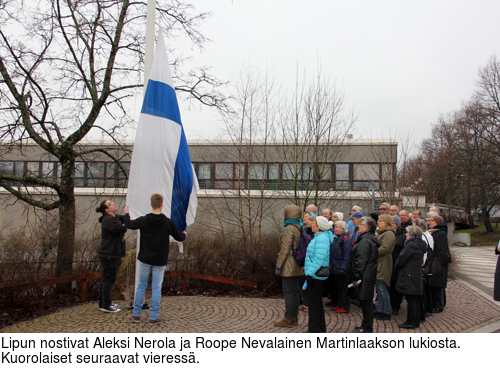 Lipun nostivat Aleksi Nerola ja Roope Nevalainen Martinlaakson lukiosta. Kuorolaiset seuraavat vieress.