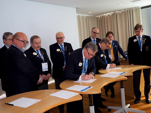 Liiton puheenjohtaja Erkki Honkala allekirjoittamassa haastetta, kuvernrit odottavat vuoroaan.