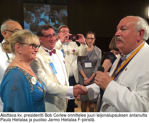 Aloittava kv. presidentti Bob Corlew onnittelee juuri leijonalupauksen antanutta Paula Hietalaa ja puoliso Jarmo Hietalaa F-piirist.