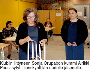 Klubiin liittyneen Sonja Orupabon kummi Airikki Pousi sytytti lionskynttiln uudelle jsenelle.