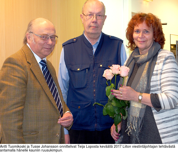 Antti Tuomikoski ja Tusse Johansson onnittelivat Teija Loposta kevll 2017 Liiton viestintjohtajan tehtvst antamalla hnelle kauniin ruusukimpun.